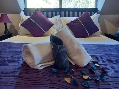 a towel animal sitting on top of a bed at Mandalay Beach Guest House in Bloubergstrand