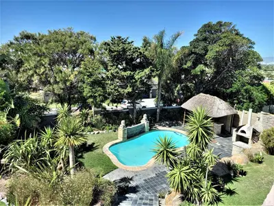 an overhead view of a swimming pool in a garden at Mandalay Beach Guest House in Bloubergstrand