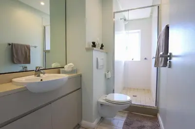 a bathroom with a sink and a toilet and a shower at Portico 1006 Beachfront Apartment with Panoramic Views in Cape Town
