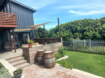 a backyard with two barrels and a fence at Kwikstertjie in Hermanus