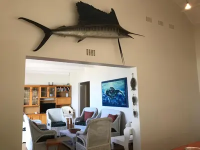 a living room with a fish hanging on the wall at La Mer, a beautiful beachfront home in Sandbaai in Hermanus