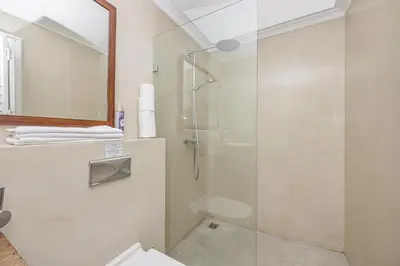 a bathroom with a shower with a glass door at The Island Beach Villa in Cape Town