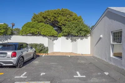 a car parked in a parking lot in front of a building at The Island Beach Villa in Cape Town