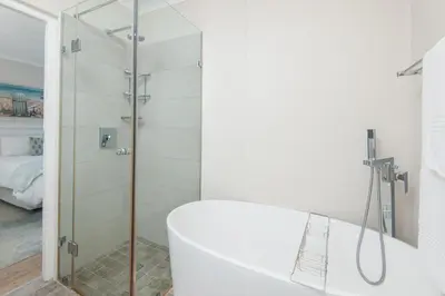 a white bathroom with a shower and a tub at 3-Bed-Mountain View in Hermanus
