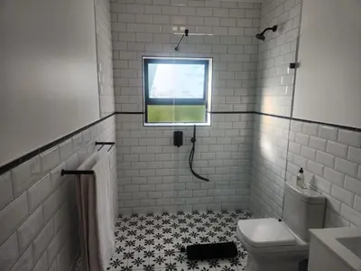 a bathroom with a toilet and a window at Boskloof Eco House I in Somerset West