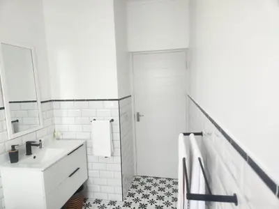 a white bathroom with a sink and a mirror at Boskloof Eco House I in Somerset West