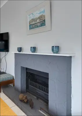 a living room with a gray fireplace with two bowls on top at Island Time in Hermanus