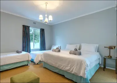 a bedroom with two beds and a window at Island Time in Hermanus