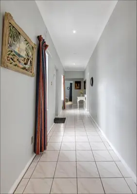 a hallway with white walls and a painting on the wall at Island Time in Hermanus