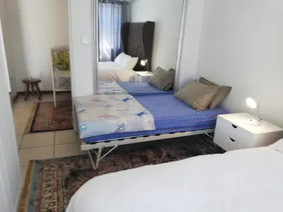 a mirror in a room with a bed and a bed sqor at Rondebosch East Garlandale STRICTLY HALAAL, fresh garden cottage in Cape Town