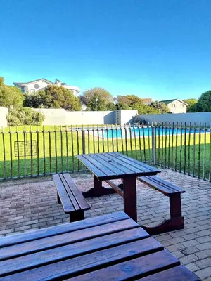a picnic table and benches in front of a fence at 81 Kingfisher in Lake Marina