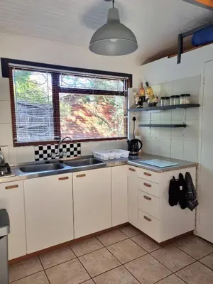a kitchen with white cabinets and a sink and a window at 81 Kingfisher in Lake Marina