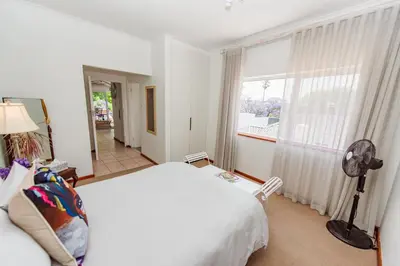 a bedroom with a white bed and a window at Luxury suite near Church Street in Stellenbosch