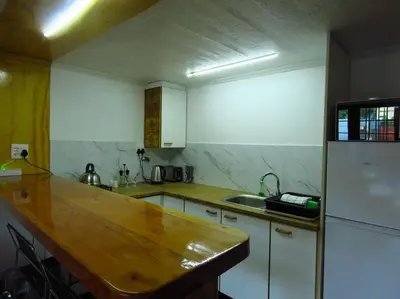 a kitchen with a wooden counter top and a refrigerator at De Kelder in Cape Town